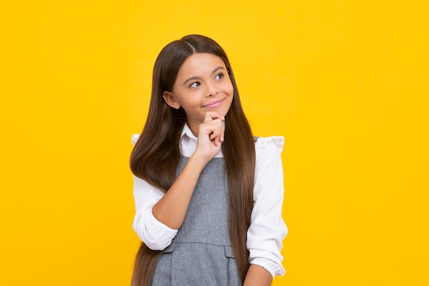 Doordachte tiener kind meisje op gele achtergrond portret van een kind denken over idee Peinzend meisje denken gezicht doordachte emoties van tiener meisje