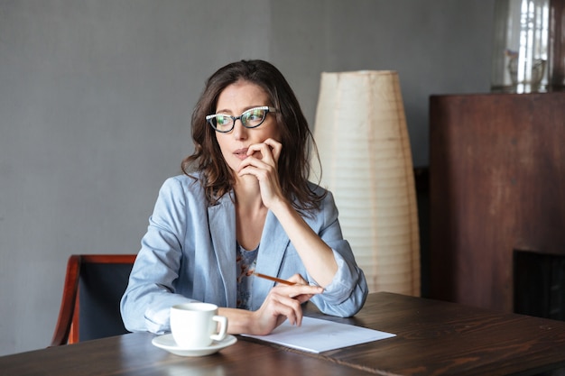 Doordachte vrouw schrijver zitten binnenshuis