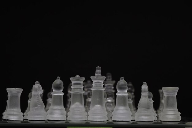 Doorschijnend schaakstuk confronteert met transparant schaakstuk met donkere achtergrond