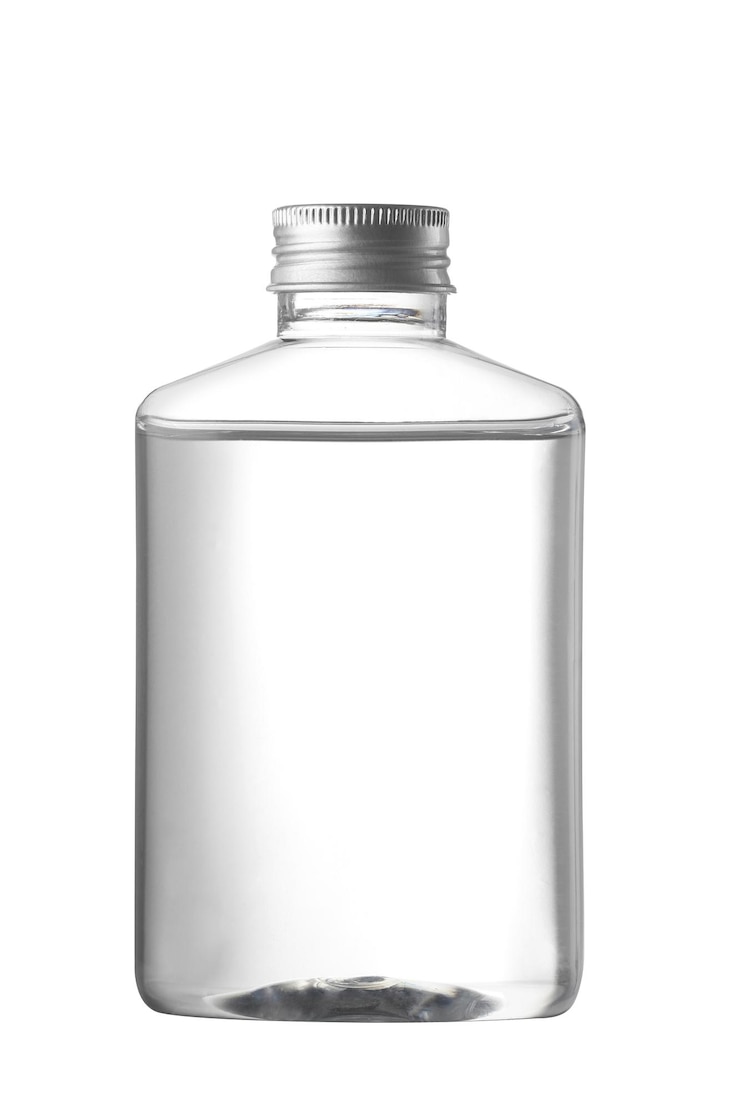 Doorzichtige plastic fles met vloeistof op witte achtergrond
