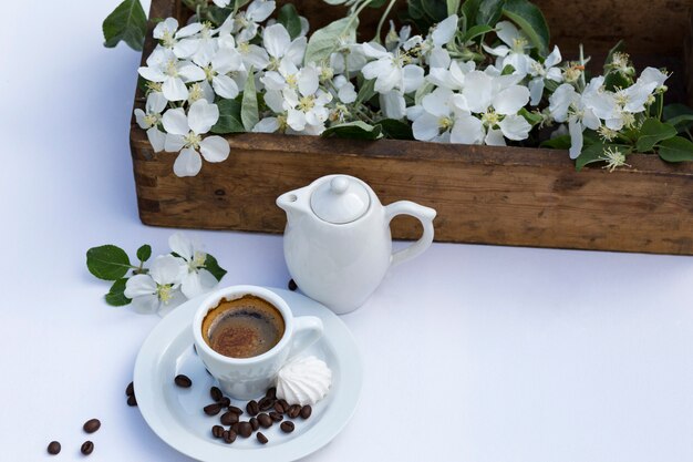 doos met appelboomtakken, een kopje koffie, een theepot, meringue en koffiebonen