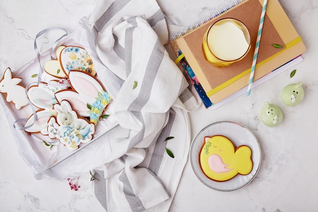 Doos met paaskoekjes Servies met glas melk en gedecoreerde geglazuurde koekjes Lente gezellige esthetische tafel