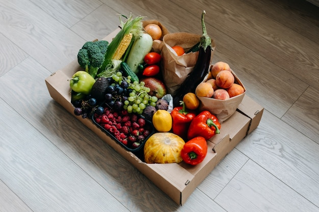 Doos vol met verschillende biologische groenten, fruit en bessen Food delivery concept