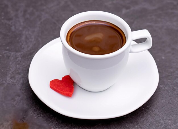 dop van koffie met een hart op het bord met taart