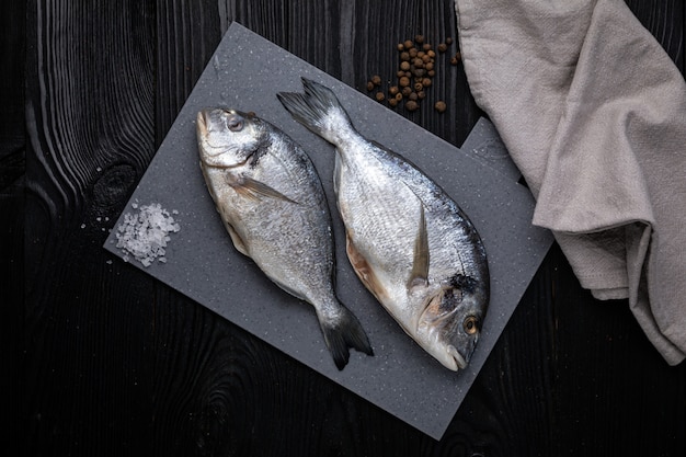 Dorada on a grey board and dark wooden table