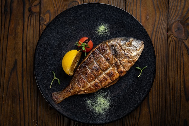 Photo dorada grilled on plate with vegetables