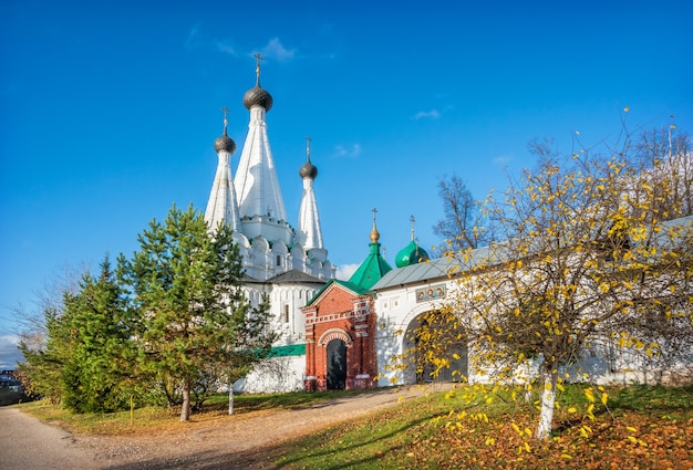 Dormition Divnaya 교회와 가을 태양 광선에 우글 리치에있는 Alekseevsky 수도원의 입구 게이트