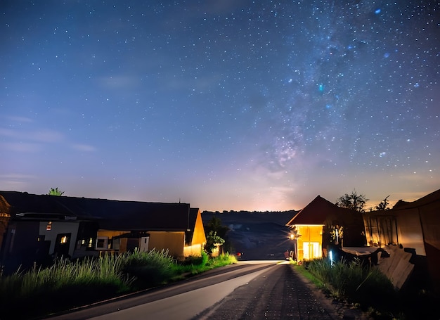 dorp op nachtelijke sterrenhemel gloeiend weglandschap op sluitertijd