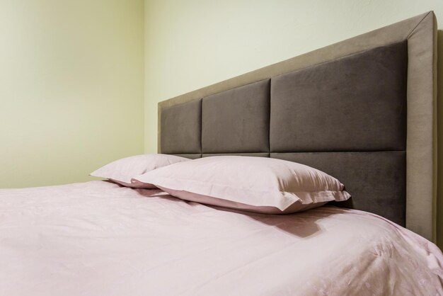 Double bed with pillows in interior of the modern intimate
bedroom in loft flat in light color style apartments