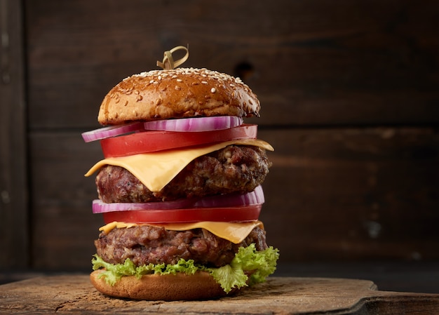 Double cheeseburger with tomatoes, onions, barbecue cutlet and sesame bun