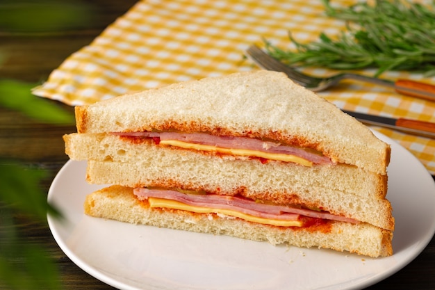 Double club sandwich served on plate on wooden table