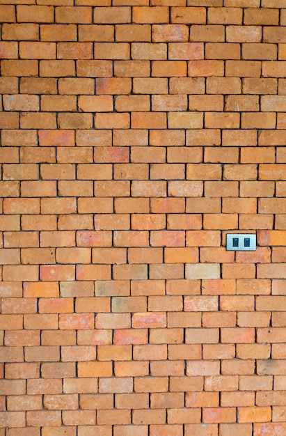 Double electrical light switch on red brick wall texture and concrete background