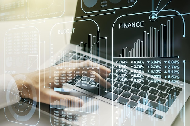 double exposure of abstract creative statistics data hologram with hands typing on laptop on background analytics and forecasting concept