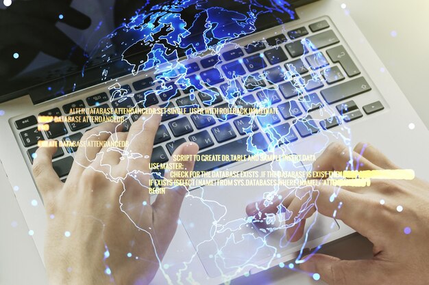 double exposure of abstract programming language hologram with world map and hands typing on laptop on background research and development concept