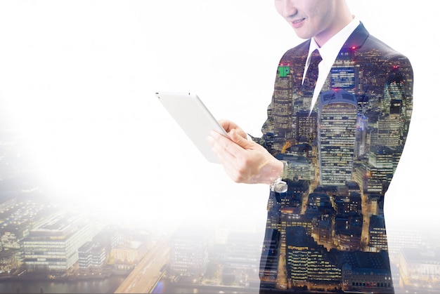 Double exposure of Asian businessman using the tablet 