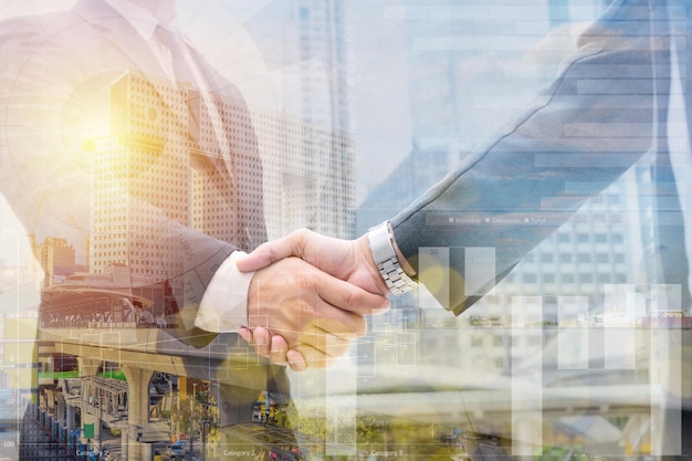 Double exposure of business handshake for successful of investment deal and Twilight view cityscape background teamwork and partnership concept