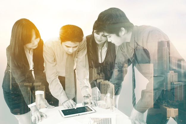 Double exposure of business team using a tablet