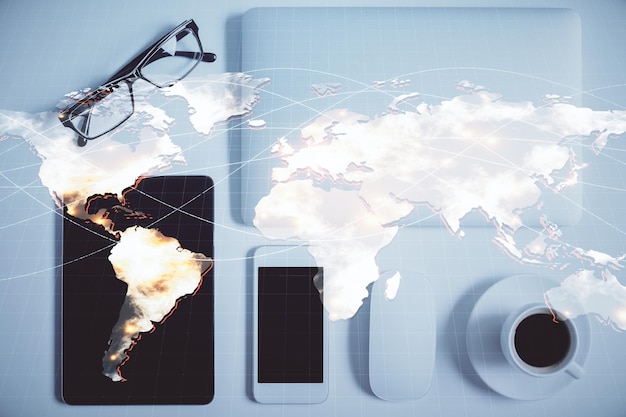 Double exposure of business theme hologram over desktop with phone Top view Mobile international trade connection concept