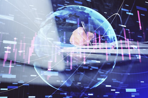 Double exposure of businessman's hands with laptop and stock market graph background Concept of research and trading