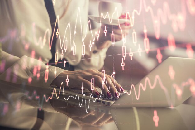 double exposure of businesswoman hands typing on computer and financial graph hologram drawing stock market analysis concept