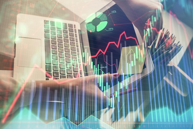 Двойная экспозиция рук бизнесменки, печатающей на компьютере и рисующей финансовый график голограммы Концепция анализа фондового рынка