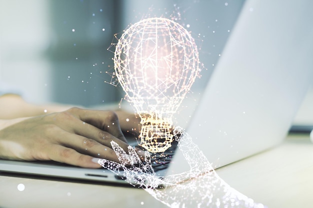 Photo double exposure of creative light bulb hologram with hands typing on laptop on background research and development concept