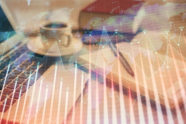 Double exposure of financial chart drawing and desktop with coffee and items on table background Concept of forex market trading