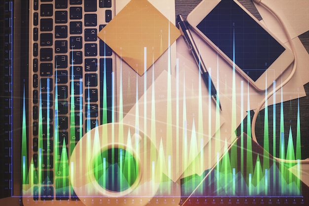 Foto doppia esposizione del grafico finanziario che disegna sullo sfondo della tabella con il computer concetto di ricerca e analisi vista dall'alto