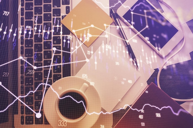 Double exposure of financial chart drawing over table background with computer Concept of research and analysis Top view