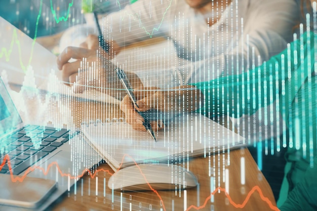 Double exposure of forex chart drawing over people taking notes background Concept of financial analysis