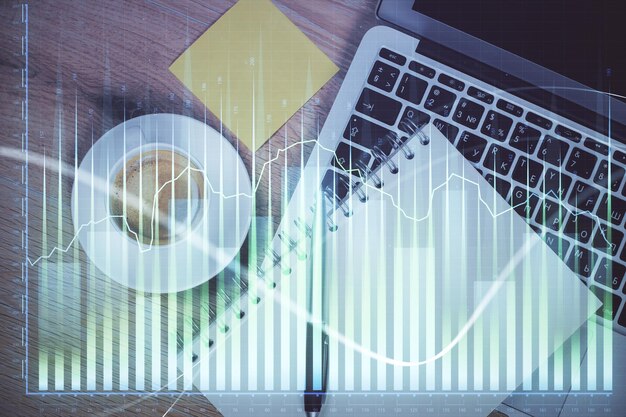 Double exposure of forex chart drawing over table background with computer Concept of financial research and analysis Top view