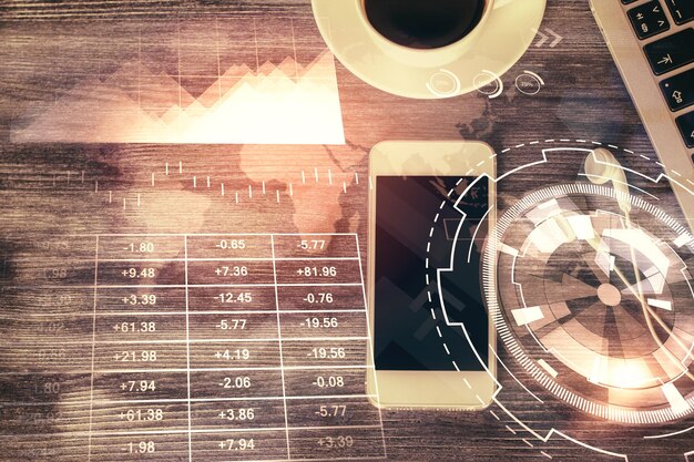 Double exposure of forex chart hologram over desktop with phone top view mobile trade platform concept