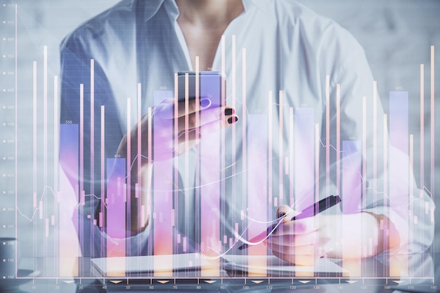 Double exposure of forex chart sketch hologram and woman holding and using a mobile device Financial market concept