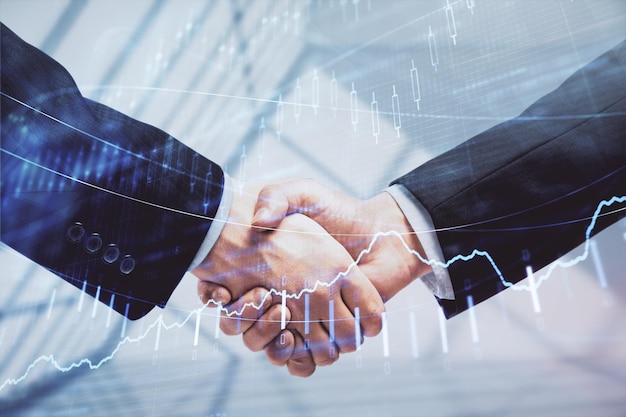 Double exposure of forex graph hologram and handshake of two men Stock market concept