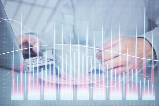 Double exposure of graph with man typing on computer in office on background Concept of hard work