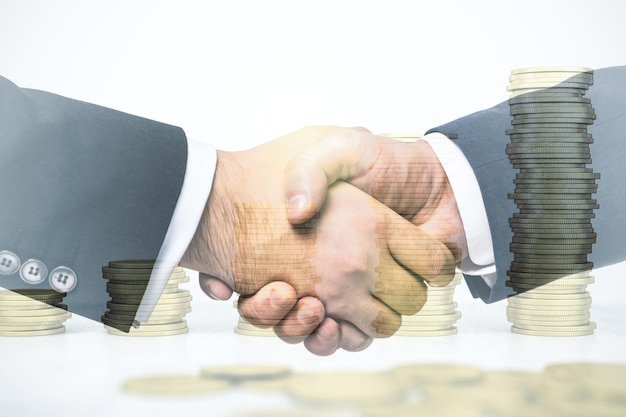 Photo double exposure of handshake two businessmen on growing stacks of coins on background development and achievement of goals concept