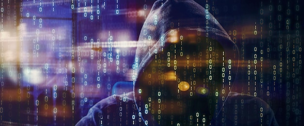 double exposure of hooded hacker with binary code