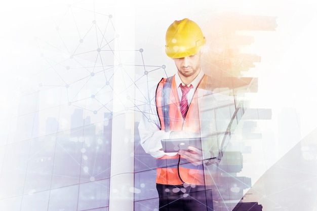 Double exposure of male engineer using a tablet