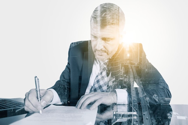 Double exposure of male manager signing a document