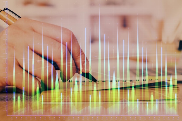 Double exposure of man doing notes of stock market with forex graph Concept of research and trading