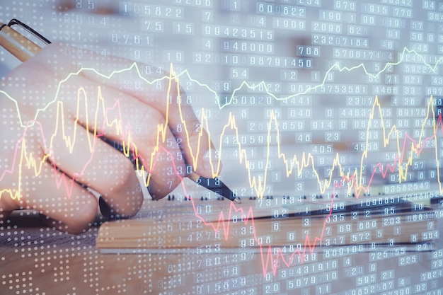 Double exposure of man doing notes of stock market with forex graph