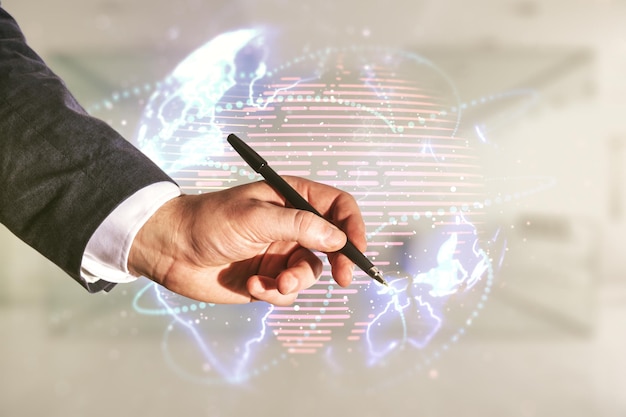 Double exposure of man hand with pen working with abstract digital world map hologram with connections on blurred office background big data and blockchain concept