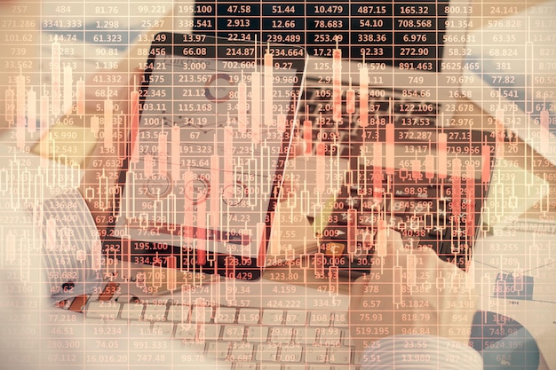 Double exposure of man's hands holding and using a digital device and forex graph drawing Financial market concept