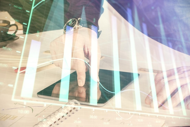 Photo double exposure of man's hands holding and using a digital device and forex graph drawing financial market concept