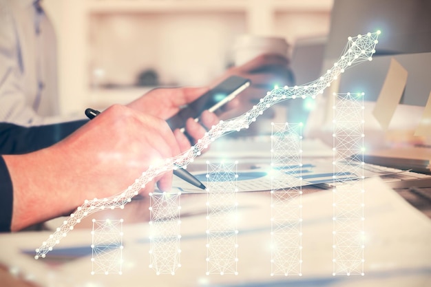 Double exposure of man's hands holding and using a phone and financial chart drawing Market analysis concept