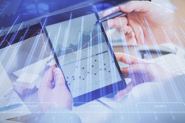 Double exposure of man's hands holding and using a phone and financial chart drawing Market analysis concept