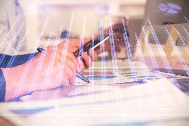 Double exposure of man's hands holding and using a phone and financial chart drawing Market analysis concept