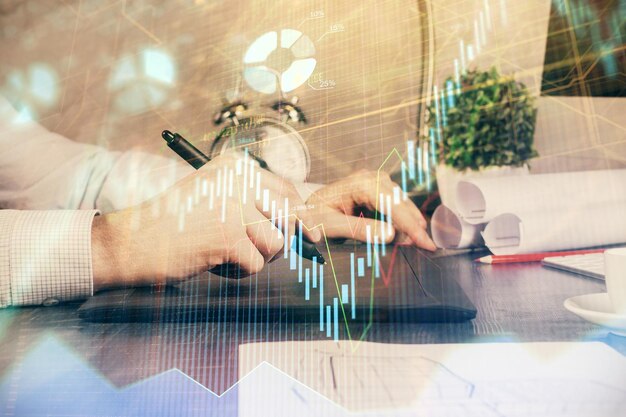 Double exposure of man's hands holding and using a phone and financial graph drawing Analysis concept