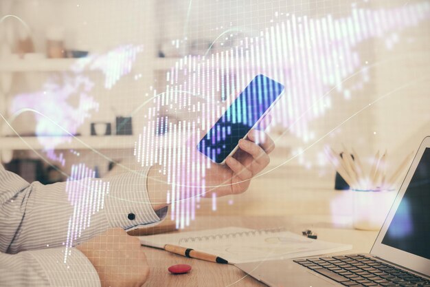 Double exposure of man's hands holding and using a phone and international business theme drawing