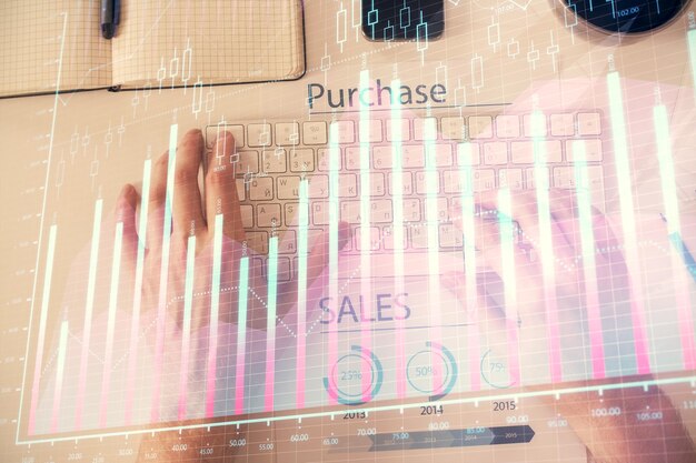 Photo double exposure of man's hands typing over laptop keyboard and forex chart hologram drawing top view financial markets concept